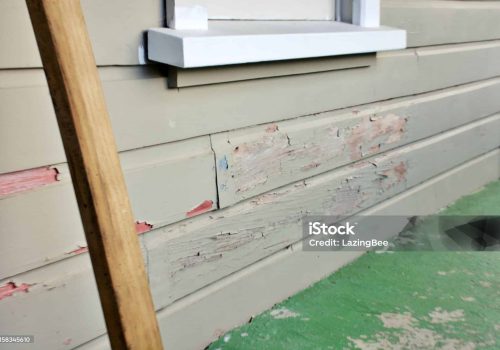 Old paint lifts and peels on a weatherboard / clapboard clad house.